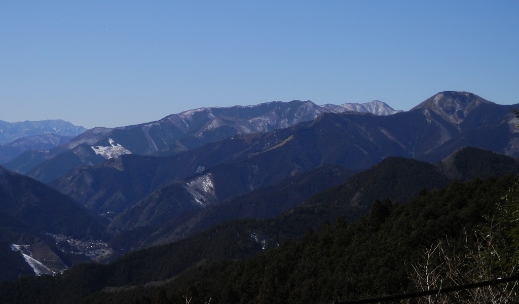 網フェンスの向こうに、石尾根を望む